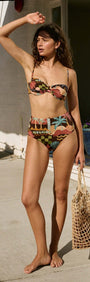 Woman wearing a Vintage Coastal Print High Waisted Bikini Bottom with a stylish top, posing outdoors.