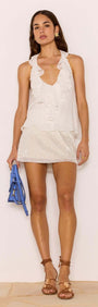 Model wearing a stylish outfit featuring a White Sequin Mini Skirt paired with a white ruffled top and blue handbag.