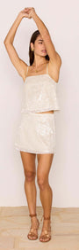 Woman wearing a White Sequin Mini Skirt styled with a matching cami top, perfect for party season.