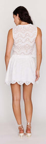 Back view of a model wearing a White Broderie Anglaise Cropped Top paired with a white skirt.