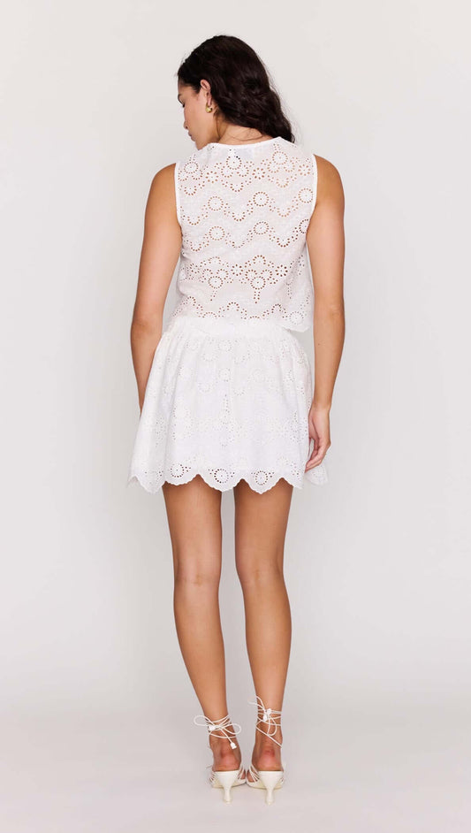 Back view of a model wearing a White Broderie Anglaise Cropped Top paired with a white skirt.