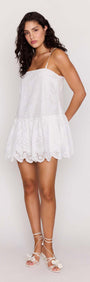 White Broderie Anglaise Mini Dress showcased on a model, featuring a sleeveless design and scalloped edging.