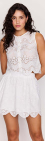 Model showcasing the White Broderie Anglaise Mini Skirt paired with a matching top, featuring delicate scalloped edges.