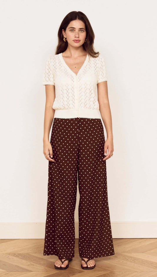 Model wearing a White Cotton Pointelle Knit Top with polka dot trousers, showcasing a stylish, feminine look.