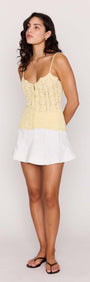 Model wearing White Denim Panel Mini Skirt paired with a yellow lace top, showcasing a trendy summer outfit.