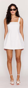 White Denim Square Neck Mini Dress model wearing with sunglasses and stylish heels, showcasing modern design and structured fit.