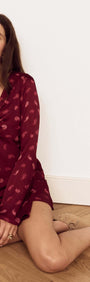 Model wearing Wine Satin Paisley Knot Front Bias Mini Dress, showcasing V-neckline and flared sleeves.