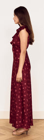 Side view of a woman wearing a Wine Satin Paisley Ruffled Bias Midi Dress, showcasing the elegant silhouette and ruffle details.