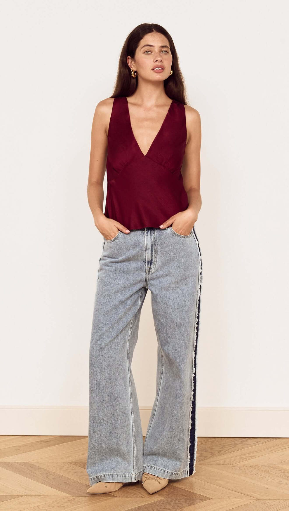 Model wearing Wine Satin V-Neck Cami Top with relaxed denim for a stylish look.