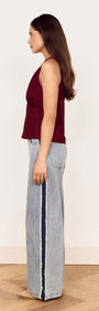 Model showcasing the Wine Satin V-Neck Cami Top paired with wide-leg jeans from a side view.