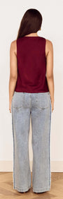 Back view of a model wearing the Wine Satin V-Neck Cami Top with wide leg denim jeans.