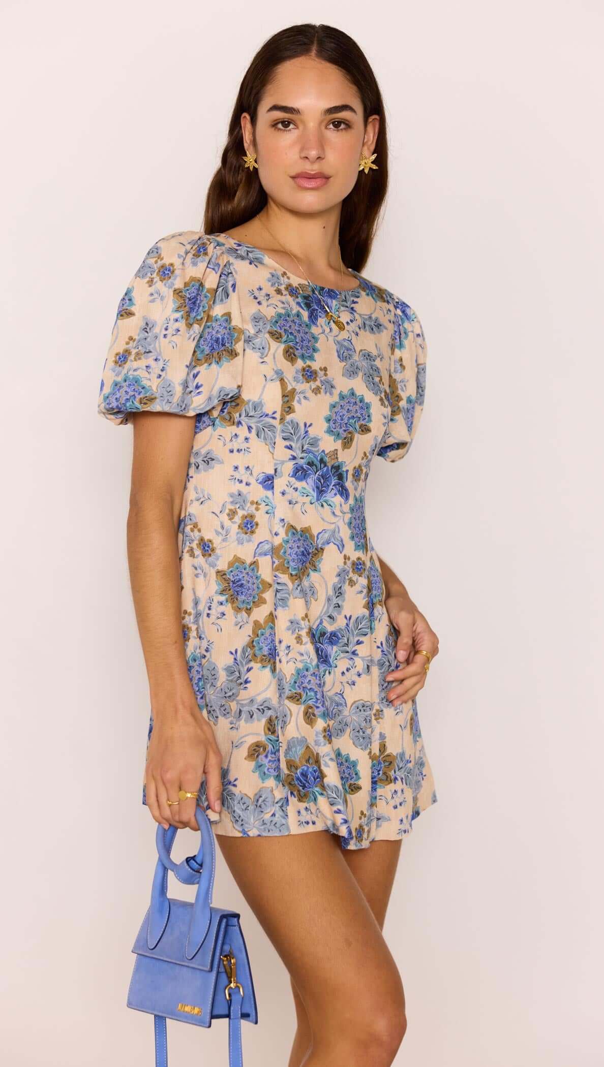 Linen Blend Blue Floral Mini Dress modeled by a woman, showcasing puff sleeves and a flattering A-line silhouette.