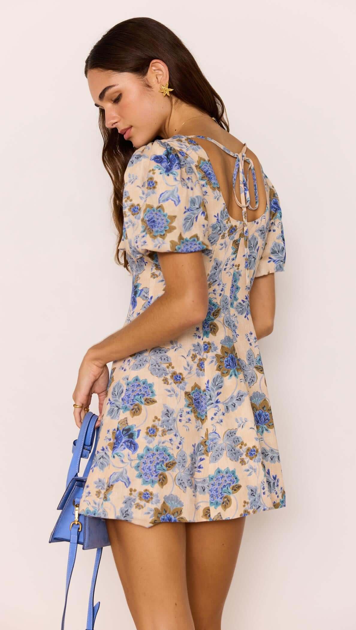 Linen Blend Blue Floral Mini Dress showcasing puff sleeves and open back with tie detail, perfect for summer outings.
