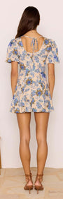 Linen Blend Blue Floral Mini Dress showcasing a back view with tie detail and puff sleeves in a blue floral print.