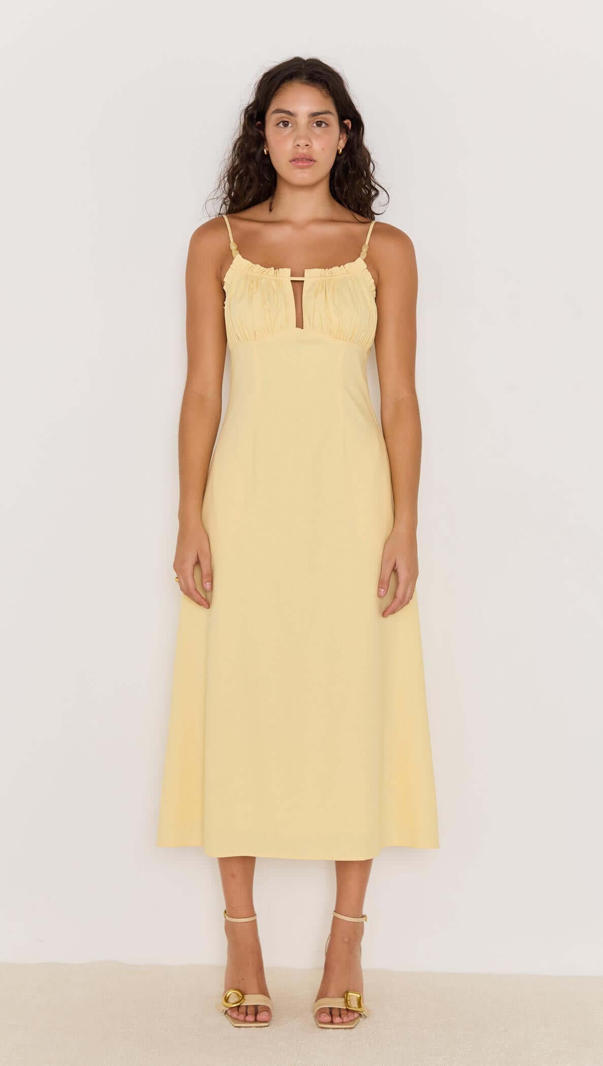 Butter yellow bias cut midi dress with spaghetti straps and front keyhole detail, perfect for summer occasions.