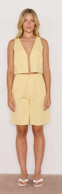 Model wearing a Butter Yellow High-Waist Bermuda Short paired with a matching sleeveless top, perfect for summer outfits.