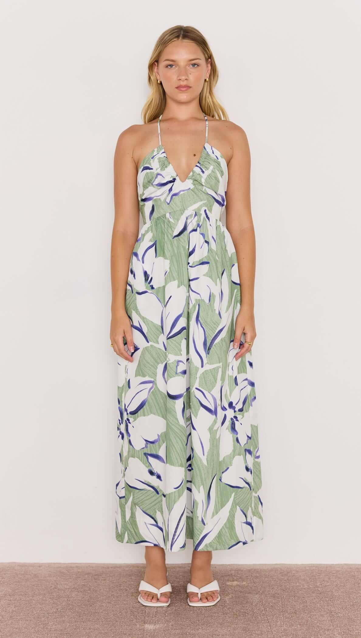 Model wearing a green and white floral halter-neck midi dress, showcasing a breezy and effortless style.