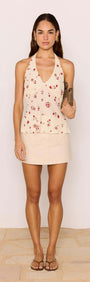 Model wearing a Beige A-Line Cotton/Linen Blend Mini Skirt paired with a floral halter top.