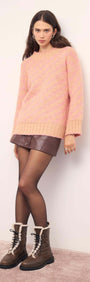 Model wearing a Pink Contrast Chunky Knit Jumper with a mini skirt and boots.