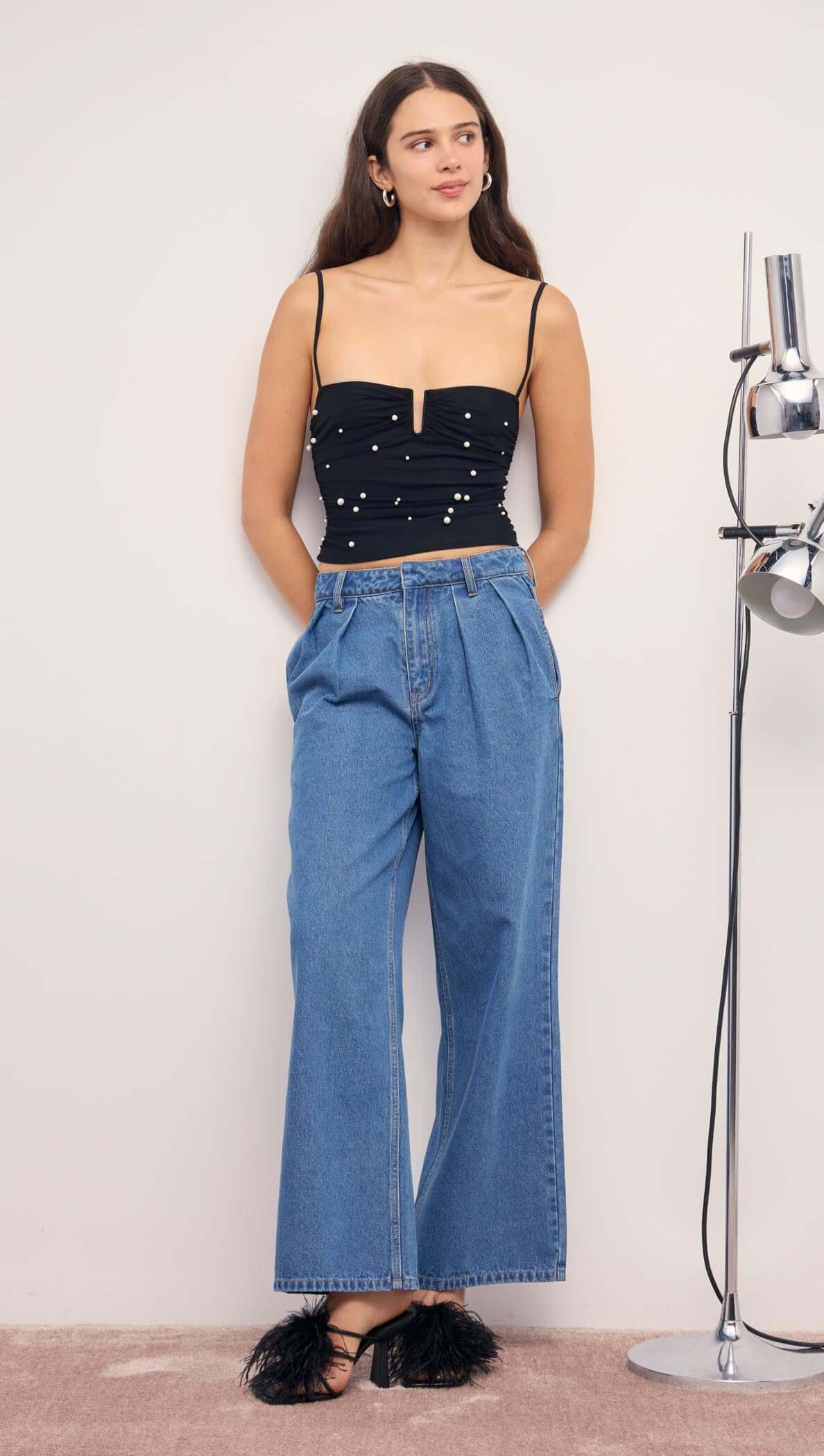 Pearl Embellished Black Mesh Crop Top paired with high-waisted denim pants and stylish heels.