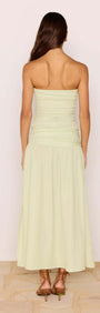 Back view of a woman wearing a Chloe Pistachio Side Split Maxi Skirt with a strapless top in soft green.