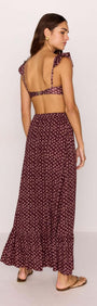 Model wearing a burgundy floral print maxi skirt with a ruffle hem and matching top, showcasing a stylish summer look.