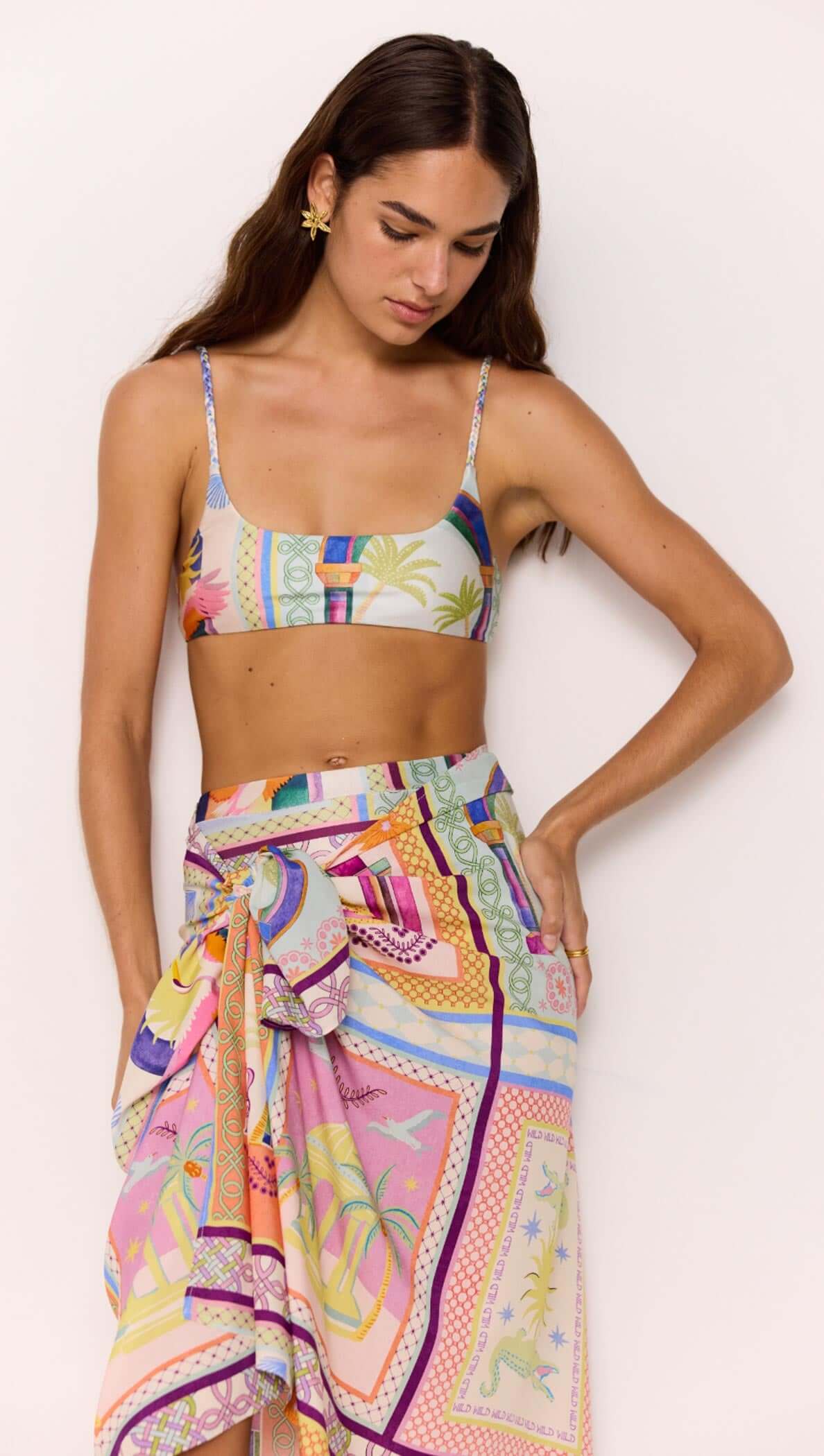 Woman wearing a colorful patterned sarong and matching top, styled with vibrant multicolour print.