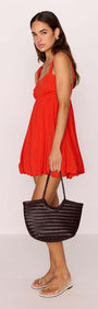 Model wearing a Scarlett Red Bubble Mini Dress with a black woven bag and stylish sandals.