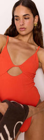 Model showcasing the Scarlett Red Cut-Out Swimsuit with V-neckline and cut-out detail, ideal for sunny beach days.