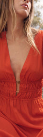 Scarlett V-Neck Midi Dress with Bead Detail in striking poppy red on a model enjoying warm summer days.