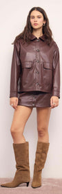 Model wearing a Brown Faux Leather Mini Skirt with a matching jacket and knee-high boots.