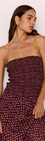 Model wearing a strapless ruched bodice maxi dress in burgundy floral print, showcasing elegant style and fit.