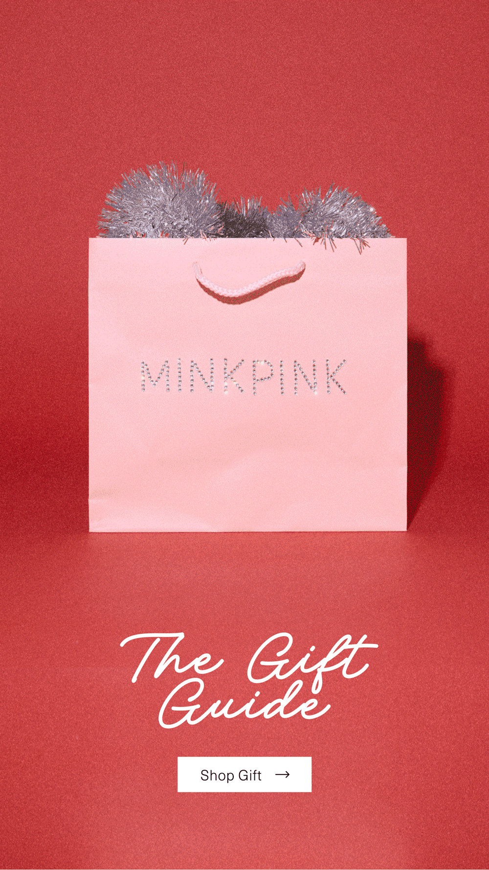 Pink MINKPINK gift bag with silver embellishments on a red background promoting the Gift Guide.