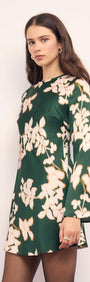 Green & Cream Floral Satin Mini Dress displayed on a model with long sleeves and floral designs against a green background.
