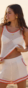 White Cotton Knit Shorts with Scallop Contrast Edge worn by model on the beach, showcasing summer fashion.