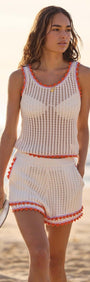 Model wearing a White Cotton Knit Top with Scallop Contrast Edge paired with matching shorts on the beach.