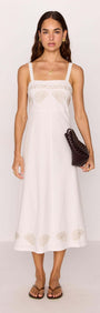 Model wearing a White Midi Dress with Embroidered Shell Detail, featuring delicate embroidery and a fitted bodice.