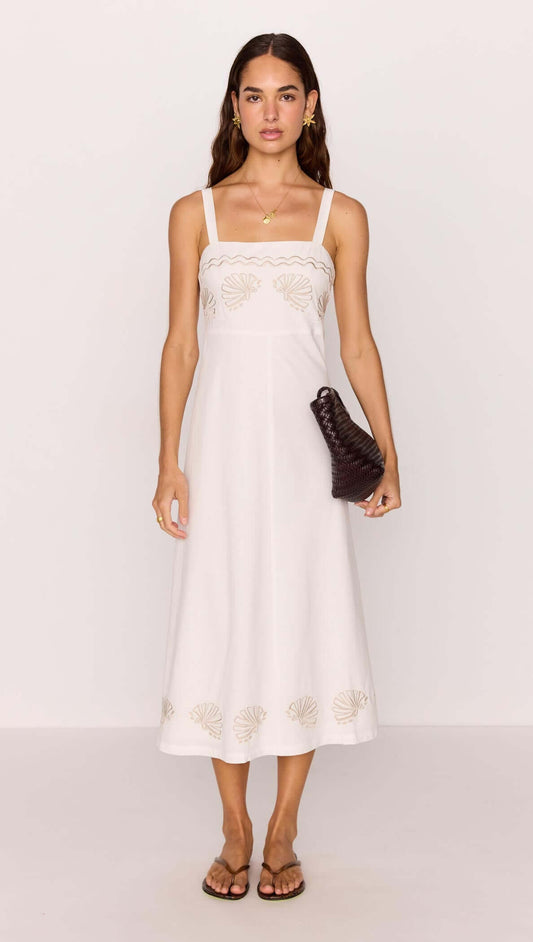Model wearing a White Midi Dress with Embroidered Shell Detail, featuring delicate embroidery and a fitted bodice.