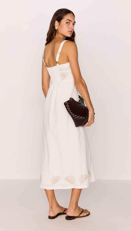 Model wearing a White Midi Dress with Embroidered Shell Detail, featuring a fitted bodice and airy A-line skirt.