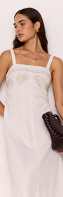 White Midi Dress with Embroidered Shell Detail worn by a model with a handbag.