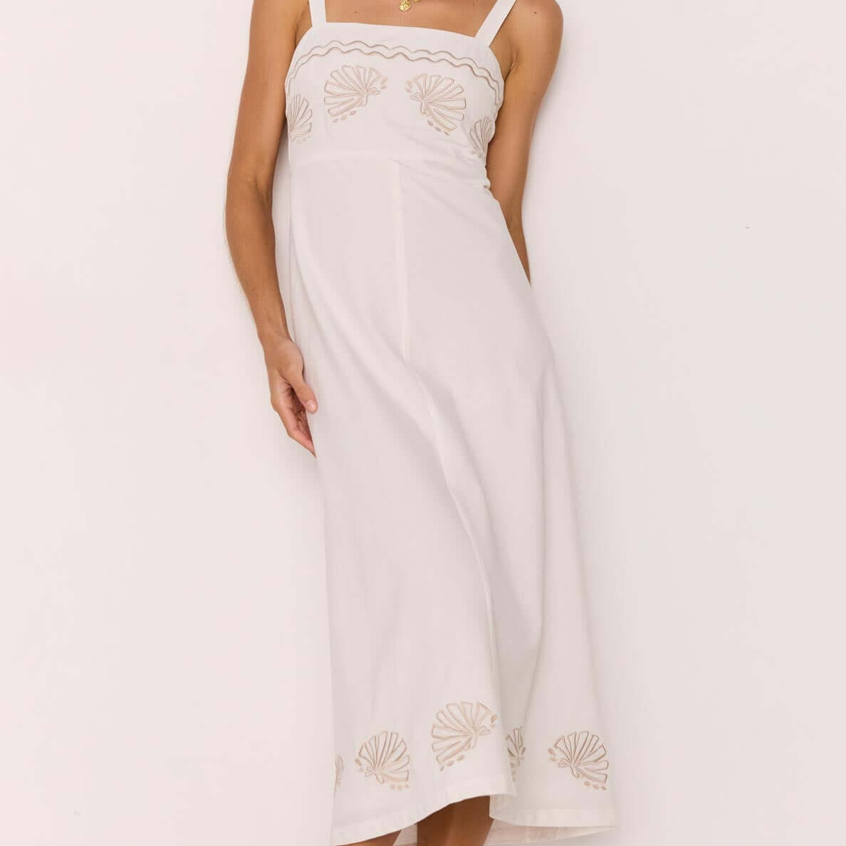 Model wearing a White Midi Dress with Embroidered Shell Detail showcasing a fitted bodice and A-line skirt.