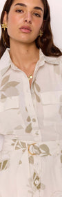 Woman wearing a White & Sage Leaf Print Playsuit with short sleeves and a collared neckline.