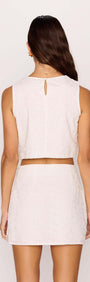 Back view of a model wearing the White Tie-Waist Crop Top paired with a matching skirt.
