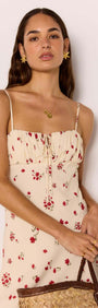 Red & Cream Floral Bias Midi Dress worn by model with floral pattern and spaghetti straps, holding a woven bag.
