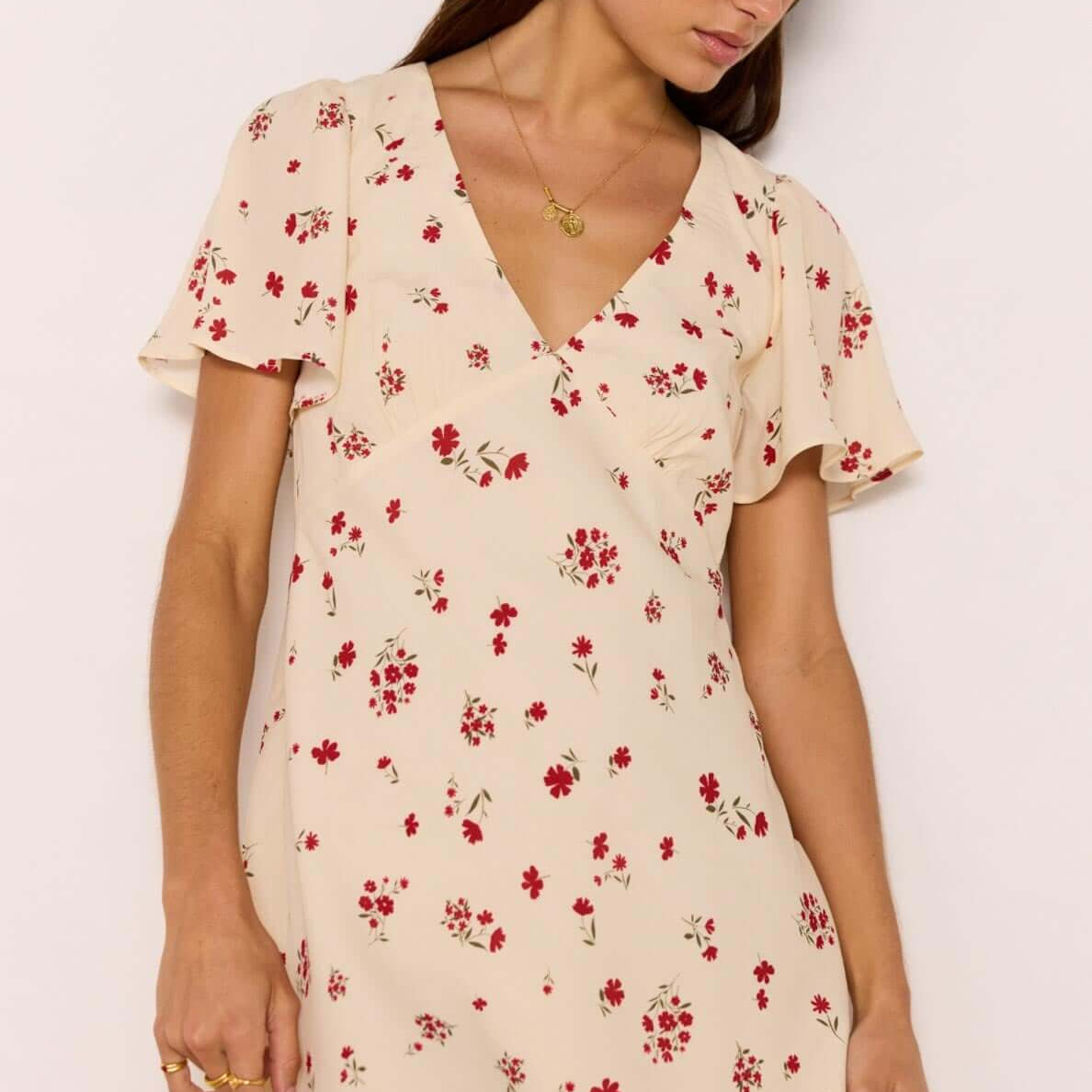 Red & Cream Floral Mini Dress displayed on a model with flutter sleeves and a flattering V-neckline.