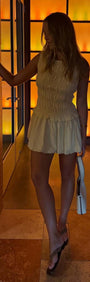 Model showcasing the Butter Yellow Shirred Bubble Mini Dress in a chic setting, highlighting its playful design and summer style.