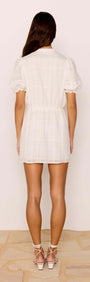 Model wearing the Lace Detail White Cotton Mini Dress, showcasing the back view with puff sleeves and elastic waist.
