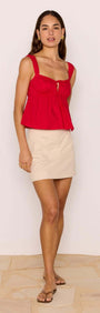 Model wearing Red Cotton Linen Blend Tie-Front Top with a beige mini skirt, showcasing a playful and chic everyday look.