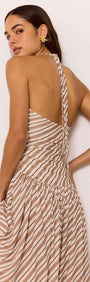 Model showcasing the back of the Brown & Cream Stripe Low-Waist Halter Maxi Dress with a breezy flowy skirt.