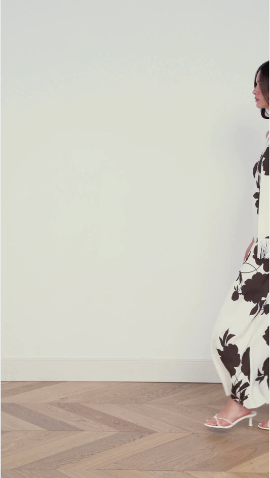 Model wearing the Brown and Cream Floral Halter Neck Maxi Dress with fringe scarf against a plain background.